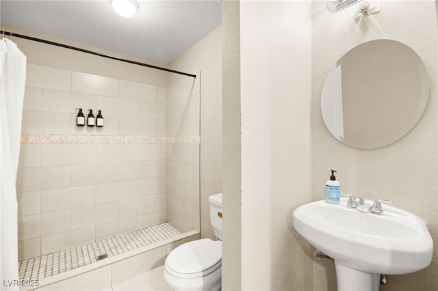 bathroom with curtained shower, toilet, and sink