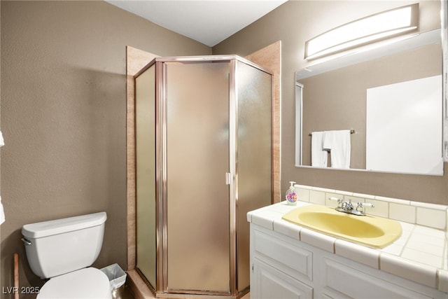 bathroom with vanity, toilet, and walk in shower