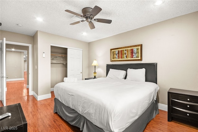 bedroom with a closet, ceiling fan, a textured ceiling, and wood-type flooring