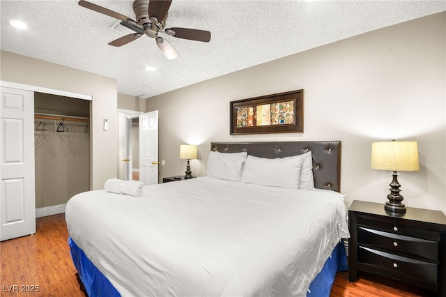 bedroom featuring a closet, ceiling fan, a textured ceiling, and hardwood / wood-style flooring