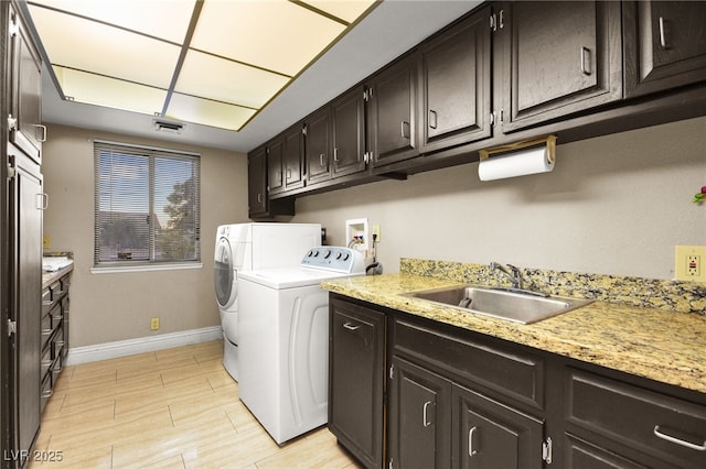 laundry room featuring cabinets, sink, and independent washer and dryer