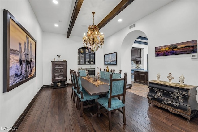 dining space featuring arched walkways, beam ceiling, dark wood finished floors, visible vents, and baseboards