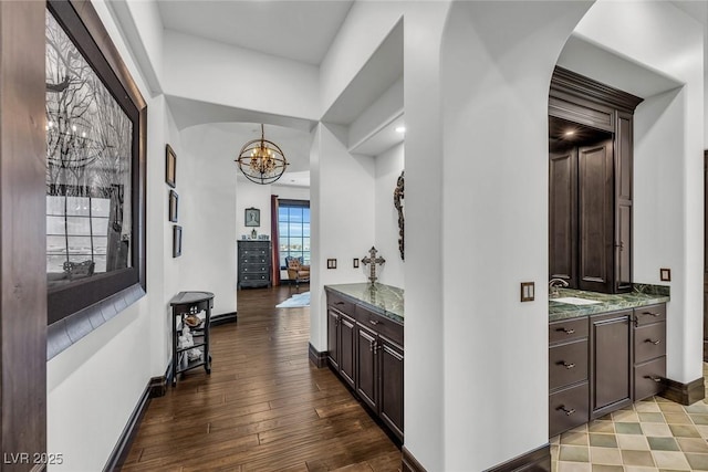 hall featuring hardwood / wood-style flooring, sink, and a notable chandelier