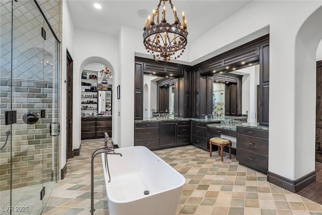 bathroom featuring vanity, built in shelves, separate shower and tub, and an inviting chandelier