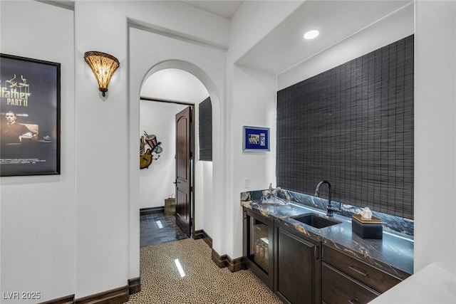 interior space with sink, dark tile patterned flooring, and dark brown cabinetry