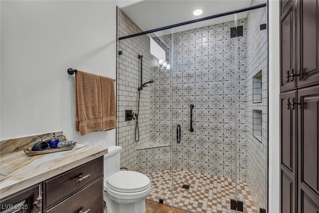 bathroom with tile patterned flooring, vanity, a shower with door, and toilet