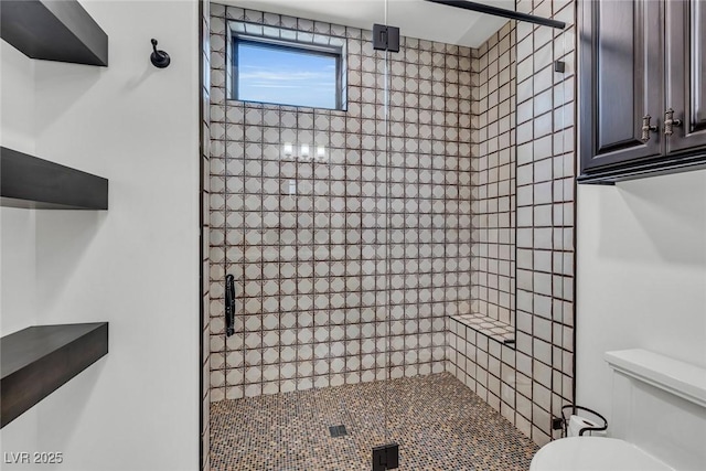 bathroom featuring tiled shower and toilet