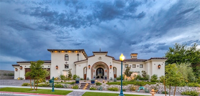 exterior space with a garage, a tiled roof, decorative driveway, and stucco siding