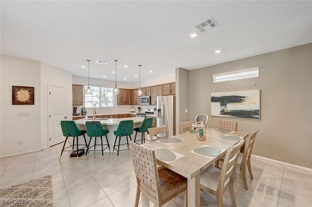 dining area featuring sink and light tile patterned floors