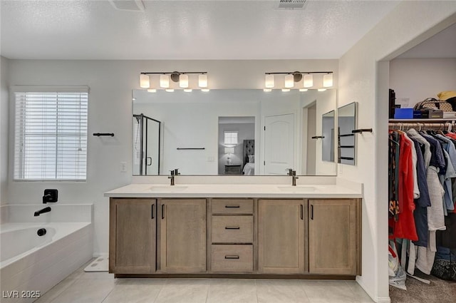 bathroom featuring a textured ceiling, tile patterned floors, and vanity