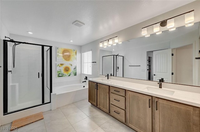 bathroom with a textured ceiling, vanity, independent shower and bath, and tile patterned flooring