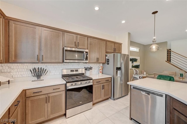 kitchen featuring pendant lighting, decorative backsplash, light tile patterned floors, and appliances with stainless steel finishes