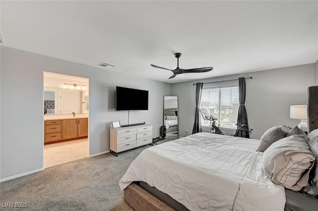 bedroom featuring light carpet, sink, ensuite bathroom, and ceiling fan