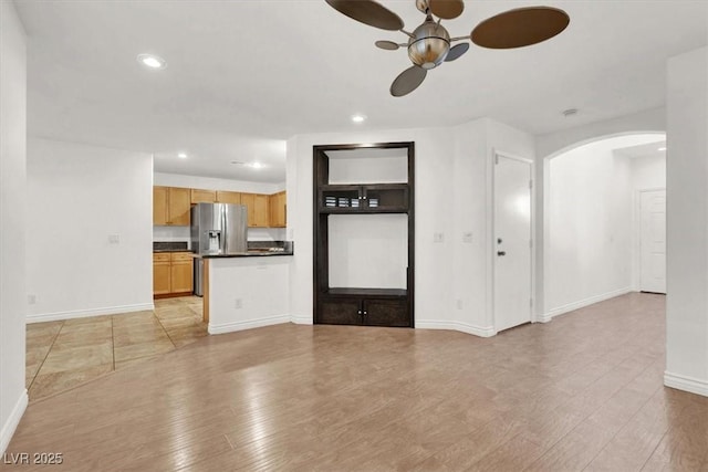 unfurnished living room with light wood-type flooring and ceiling fan