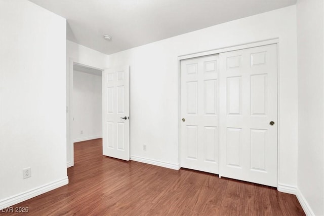 unfurnished bedroom featuring dark wood-type flooring and a closet