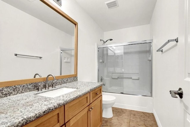 full bathroom featuring toilet, tile patterned flooring, enclosed tub / shower combo, and vanity