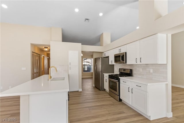 kitchen featuring sink, white cabinetry, high vaulted ceiling, stainless steel appliances, and backsplash