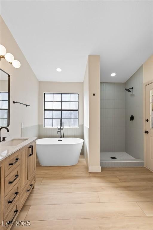 bathroom with vanity, separate shower and tub, and hardwood / wood-style floors