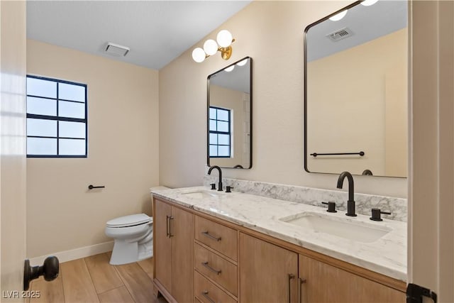 bathroom with vanity, toilet, and hardwood / wood-style floors