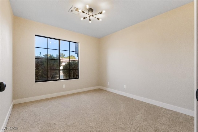 spare room with a chandelier and carpet floors