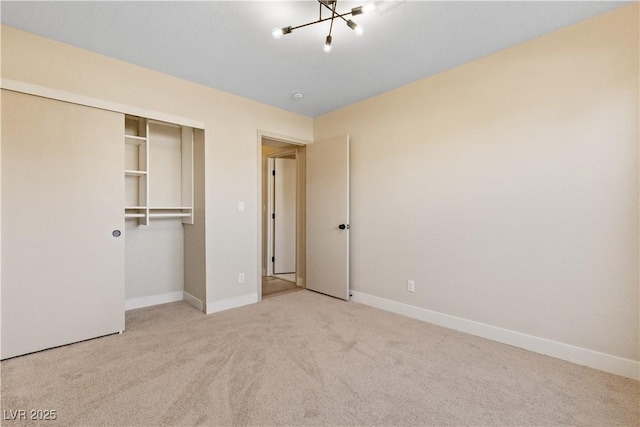 unfurnished bedroom featuring light carpet and a closet