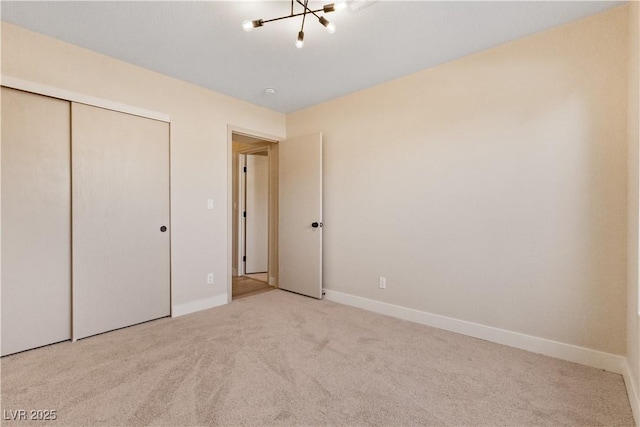 unfurnished bedroom with a chandelier, light carpet, and a closet