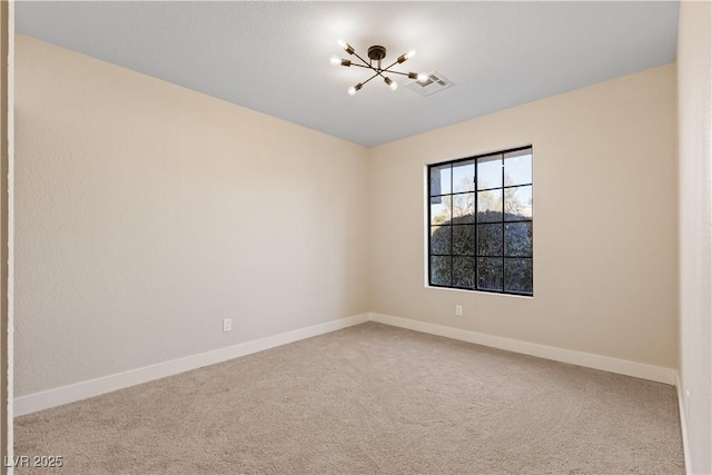 unfurnished room featuring carpet and a chandelier