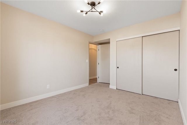 unfurnished bedroom with light colored carpet and a closet