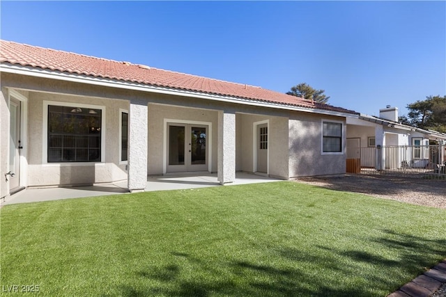 rear view of house featuring a lawn and a patio area