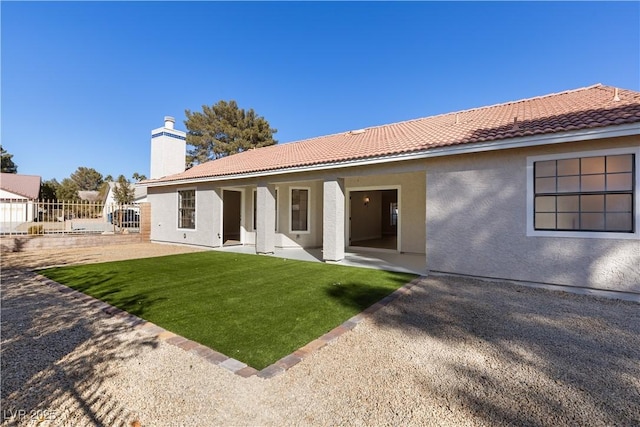 back of house featuring a patio and a yard