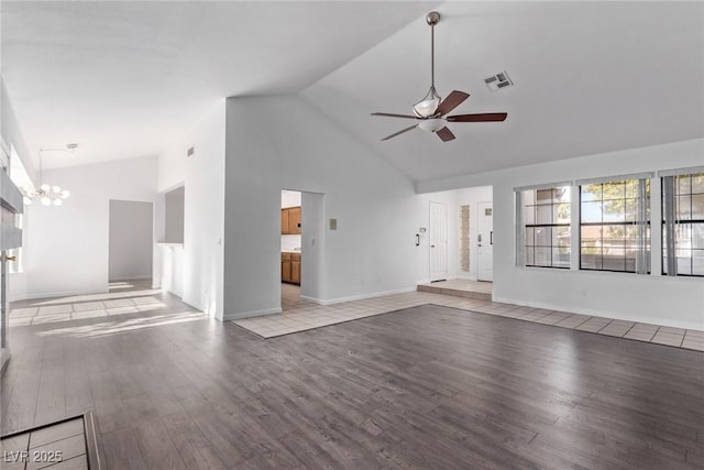 unfurnished living room featuring ceiling fan with notable chandelier, light hardwood / wood-style flooring, and high vaulted ceiling