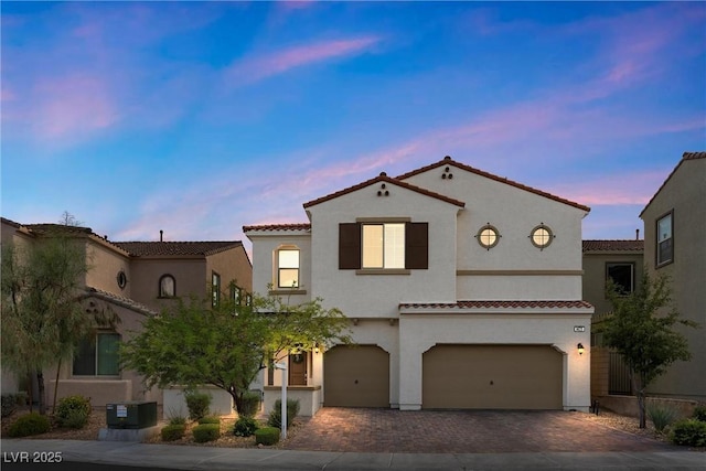 mediterranean / spanish-style home with a garage and central AC