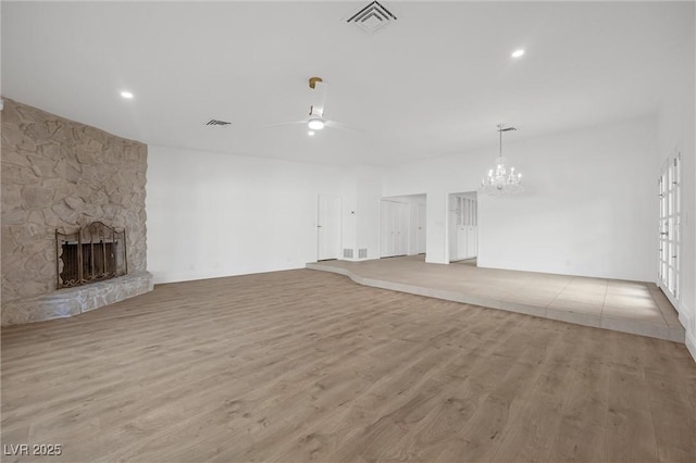 unfurnished living room with ceiling fan, light wood-type flooring, and a stone fireplace