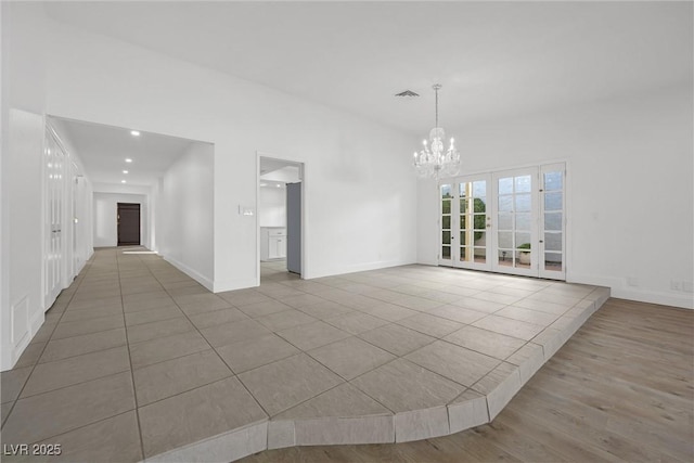 tiled empty room featuring a chandelier