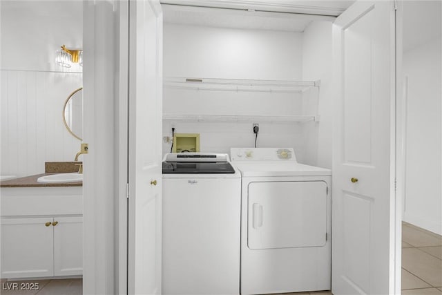 laundry area featuring sink, washing machine and clothes dryer, and light tile patterned floors