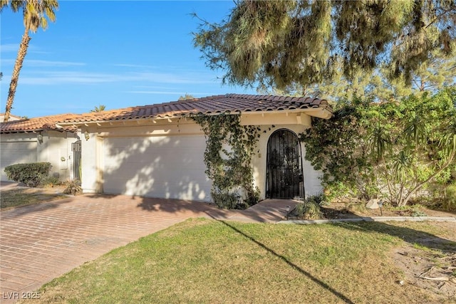 mediterranean / spanish-style house featuring a garage and a front lawn