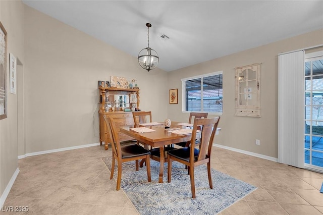 tiled dining area featuring a healthy amount of sunlight and an inviting chandelier