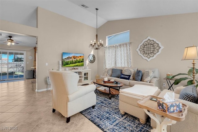 tiled living room featuring vaulted ceiling and ceiling fan with notable chandelier