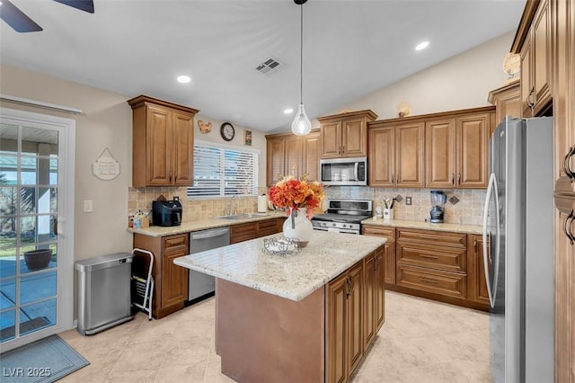 kitchen featuring a center island, pendant lighting, backsplash, stainless steel appliances, and lofted ceiling