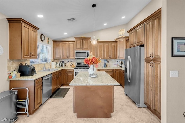 kitchen featuring pendant lighting, backsplash, a kitchen island, lofted ceiling, and stainless steel appliances