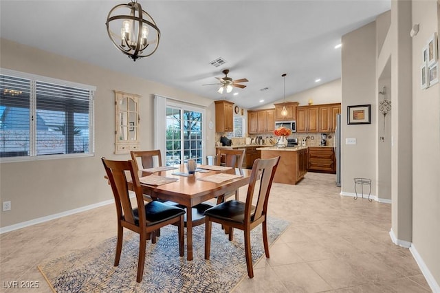 dining room featuring ceiling fan with notable chandelier and lofted ceiling