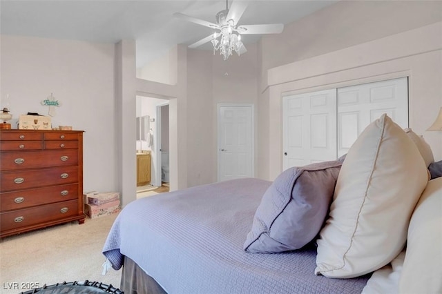 carpeted bedroom with ensuite bath, a closet, a high ceiling, and ceiling fan