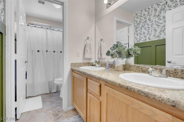 bathroom with vanity, toilet, and tile patterned floors