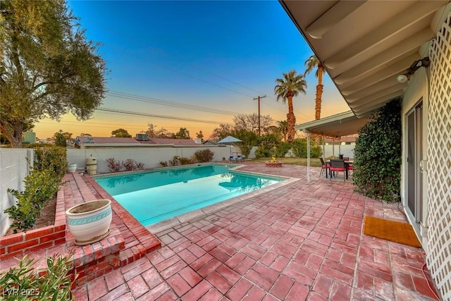 pool at dusk with a patio