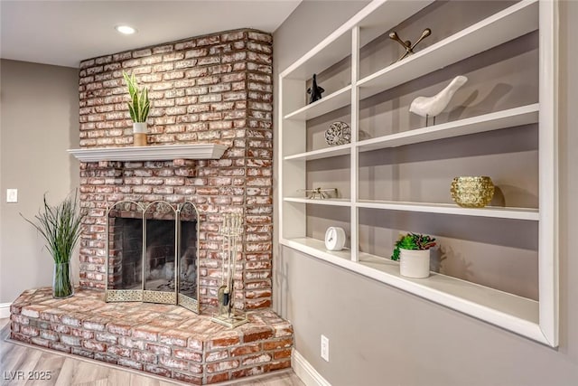 living room with hardwood / wood-style floors and a brick fireplace