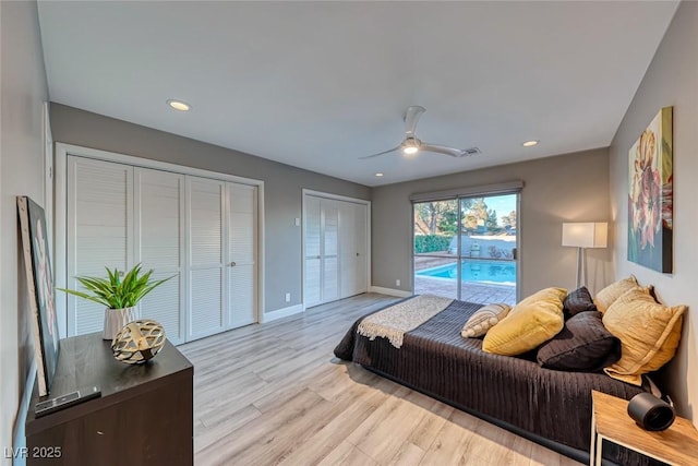 bedroom with access to exterior, two closets, light hardwood / wood-style flooring, and ceiling fan