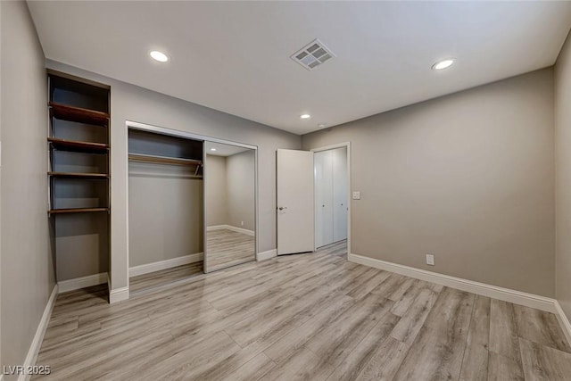 unfurnished bedroom featuring a closet and light wood-type flooring