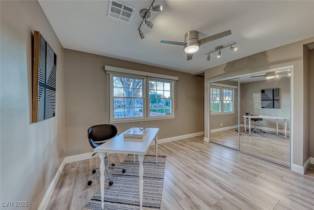 office area with light hardwood / wood-style flooring, rail lighting, and ceiling fan