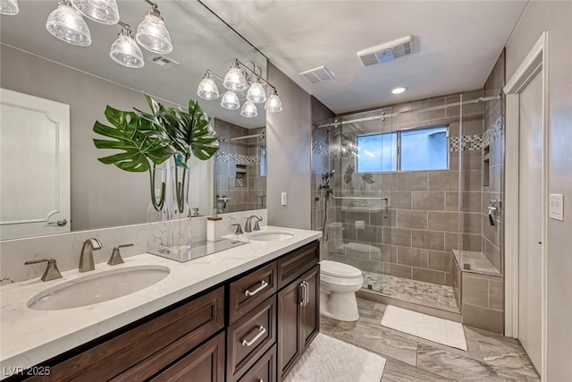 bathroom with vanity, toilet, and a shower with door