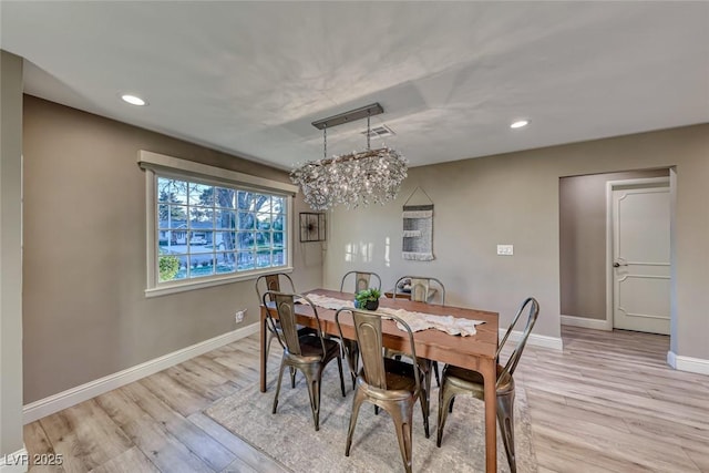 dining area featuring an inviting chandelier and light hardwood / wood-style flooring